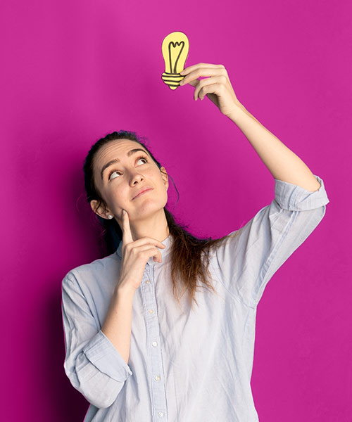 A képen egy fiatal nő látható, ahogy egy világító égőt tart, rajzolt formában az ég felé